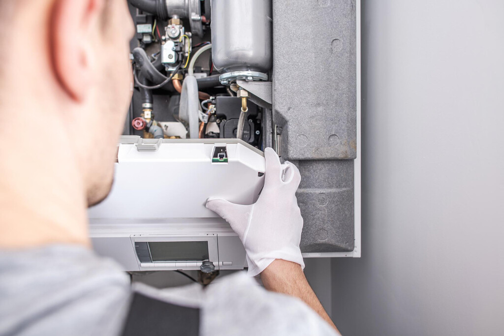 A technician in white gloves is repairing a gas boiler, ensuring safe and efficient operation.